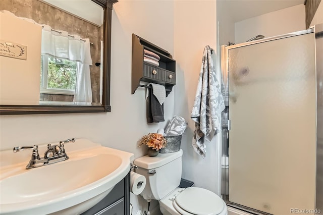 bathroom featuring toilet, vanity, and a shower stall