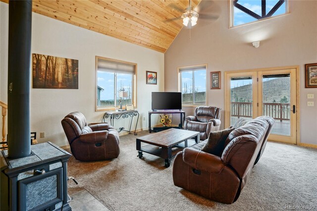 16395 Meadow Dr, Walsenburg, CO 81089 - carpeted living room featuring baseboards, ceiling fan, wood ceiling, high vaulted ceiling, and a wood stove