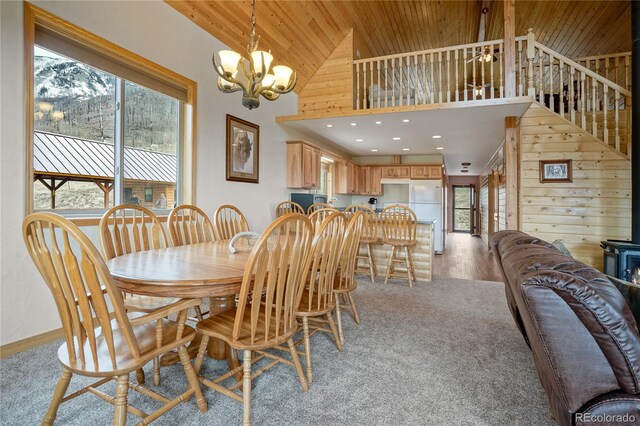 16395 Meadow Dr, Walsenburg, CO 81089 - dining area featuring wooden walls, light colored carpet, wood ceiling, high vaulted ceiling, and a notable chandelier