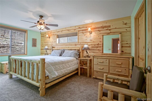 16395 Meadow Dr, Walsenburg, CO 81089 - bedroom with ceiling fan, log walls, carpet flooring, and wooden walls