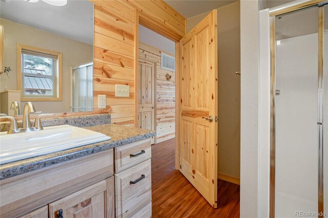 16395 Meadow Dr, Walsenburg, CO 81089 - full bathroom featuring visible vents, vanity, wood finished floors, and a shower stall