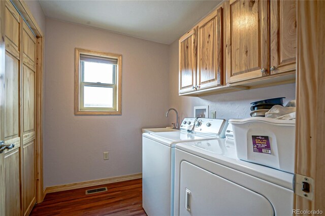 16395 Meadow Dr, Walsenburg, CO 81089 - laundry area with a sink, cabinet space, baseboards, dark wood-style flooring, and visible vents