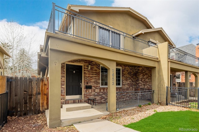 1653 S Logan St, Denver, CO 80210 - view of front of home featuring a balcony, brick siding, and a porch