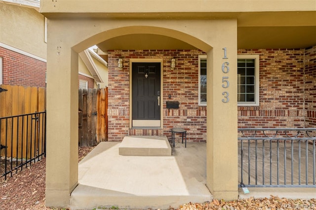1653 S Logan St, Denver, CO 80210 - property entrance featuring brick siding, a porch, and stucco siding