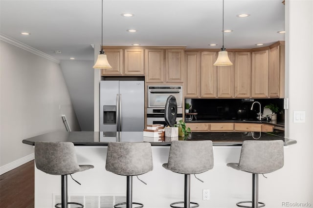 1653 S Logan St, Denver, CO 80210 - kitchen featuring appliances with stainless steel finishes, dark countertops, a kitchen breakfast bar, light brown cabinetry, and ornamental molding