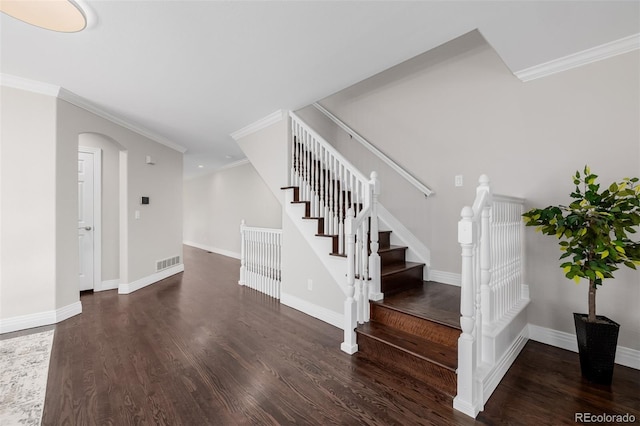 1653 S Logan St, Denver, CO 80210 - staircase with wood finished floors, arched walkways, and crown molding