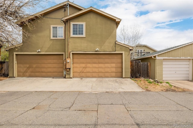 1653 S Logan St, Denver, CO 80210 - view of front facade featuring stucco siding, an attached garage, and driveway