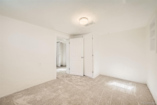 carpeted empty room featuring a textured ceiling