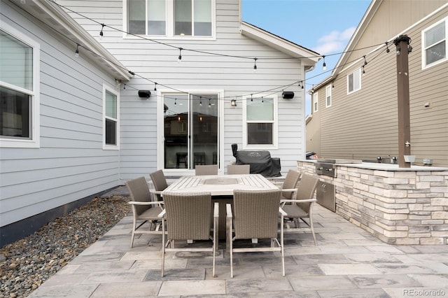 view of patio with an outdoor kitchen and a grill