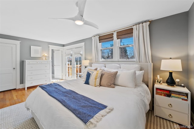 bedroom with french doors, ceiling fan, and wood finished floors