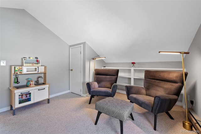 sitting room with light carpet, vaulted ceiling, and baseboards