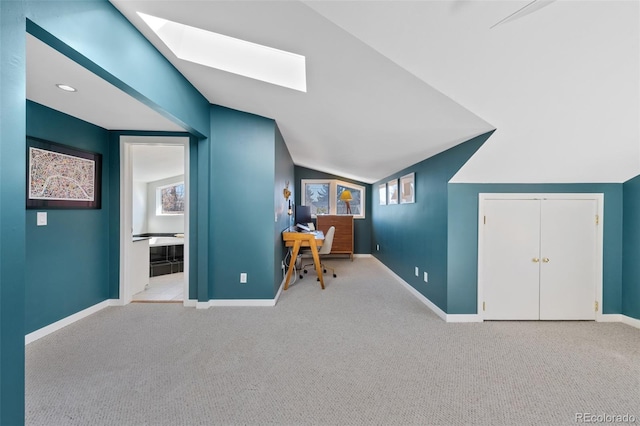 unfurnished office featuring carpet, baseboards, and vaulted ceiling