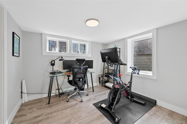 workout room featuring baseboards and wood finished floors