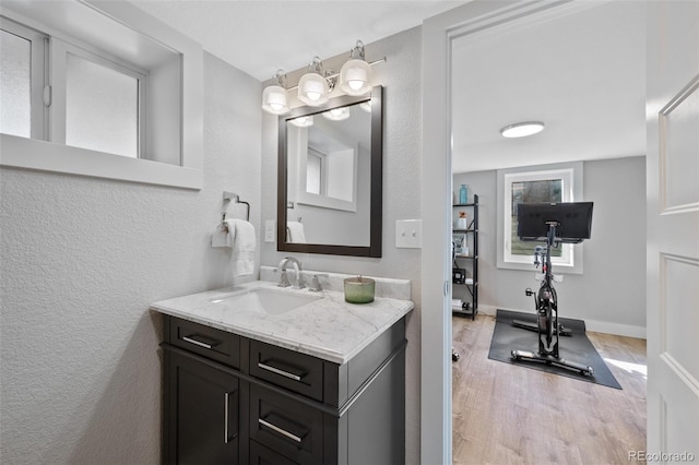 bathroom featuring a textured wall, wood finished floors, and vanity