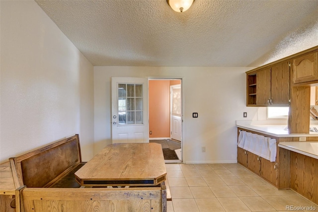 3126 Singletree Rd, Hartsel, CO 80449 - kitchen with a textured ceiling, light countertops, open shelves, light tile patterned flooring, and brown cabinets