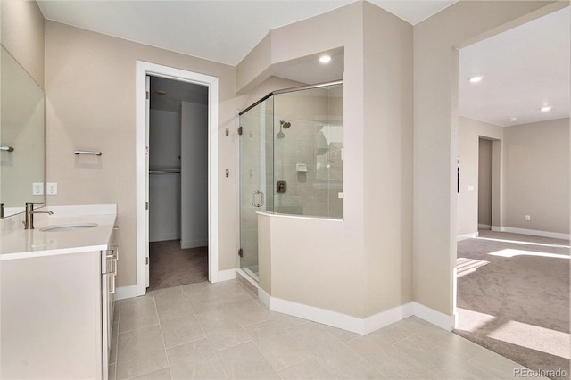 bathroom featuring tile patterned floors, baseboards, a stall shower, and vanity