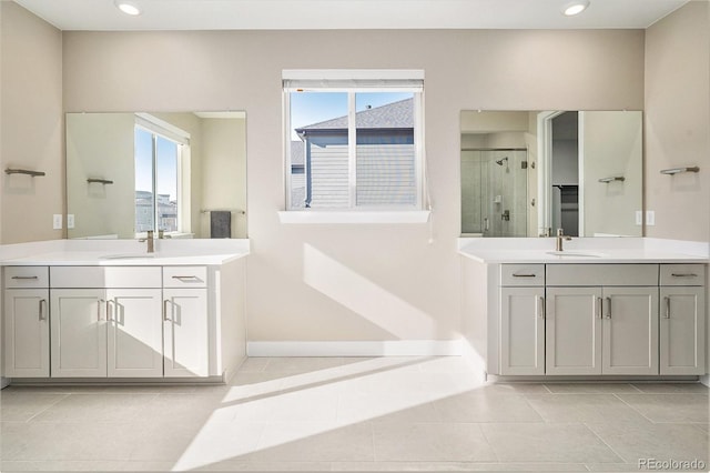 bathroom featuring a wealth of natural light, tile patterned flooring, a shower stall, and a sink