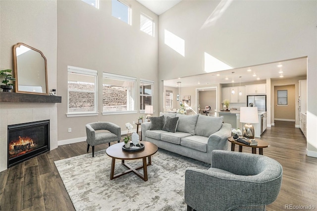 living room featuring dark wood-style floors, recessed lighting, a tile fireplace, and baseboards