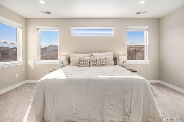 bedroom with baseboards, light carpet, and multiple windows