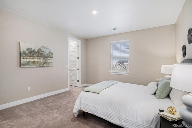 carpeted bedroom with visible vents and baseboards