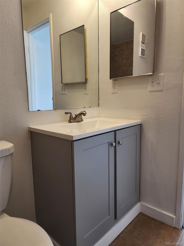 bathroom featuring tile patterned flooring, vanity, and toilet