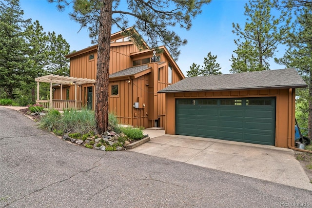 207 Kelly Rd E, Boulder, CO 80302 - view of front of home featuring a pergola, board and batten siding, a garage, and concrete driveway