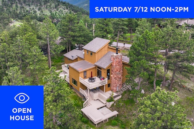 207 Kelly Rd E, Boulder, CO 80302 - aerial view of property and surrounding area featuring a forest and a mountain backdrop