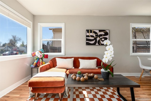 living area featuring baseboards and light wood finished floors