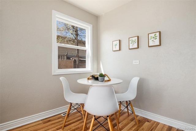 dining room with baseboards and wood finished floors
