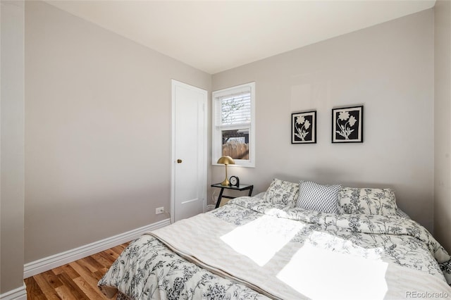 bedroom featuring baseboards and wood finished floors