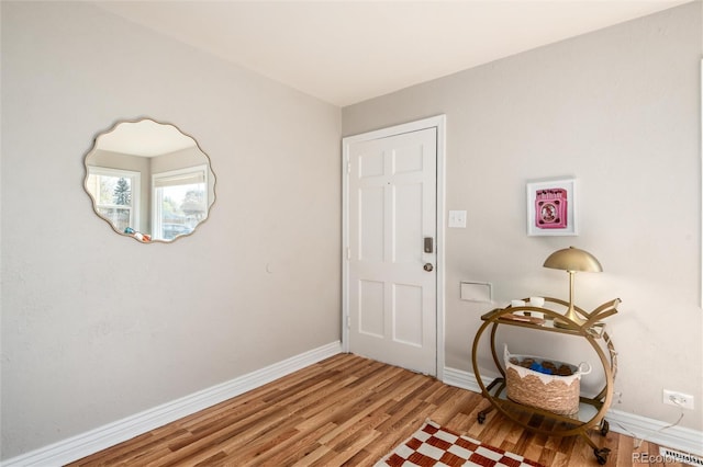 doorway to outside with baseboards and wood finished floors