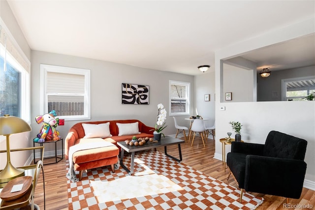 living area with baseboards and light wood finished floors