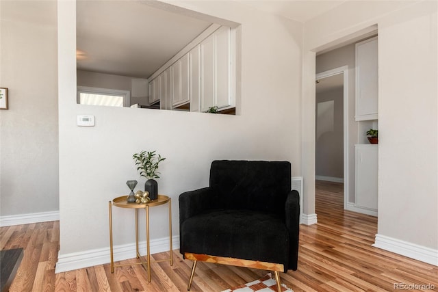 living area featuring baseboards and light wood-style flooring