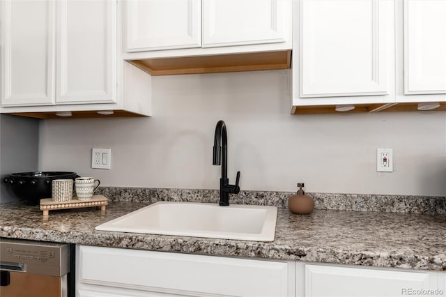 kitchen with a sink, white cabinetry, and dishwasher