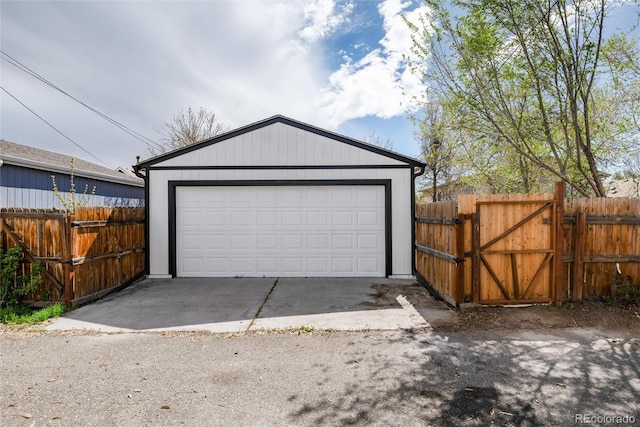detached garage with a gate and fence