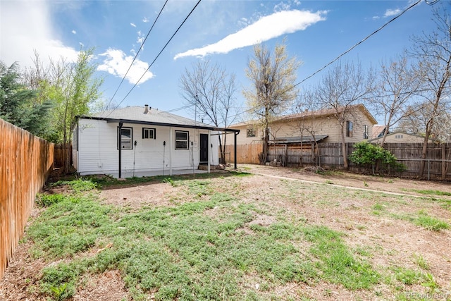 rear view of property with a fenced backyard