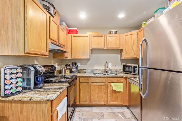 kitchen featuring light stone counters, appliances with stainless steel finishes, and sink