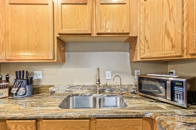 kitchen featuring sink and stone countertops