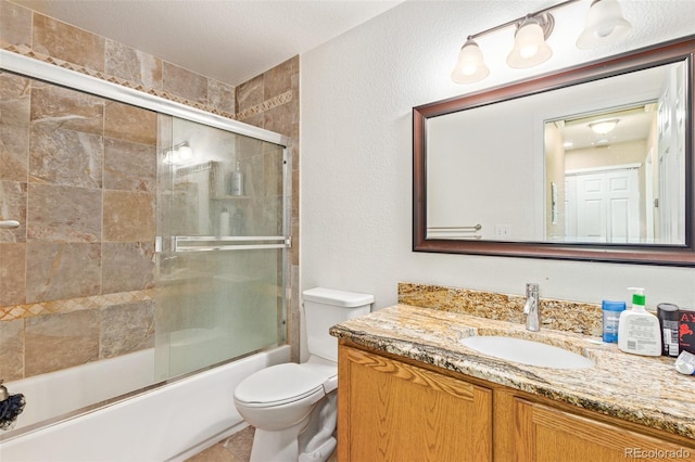 full bathroom featuring shower / bath combination with glass door, a textured ceiling, vanity, and toilet