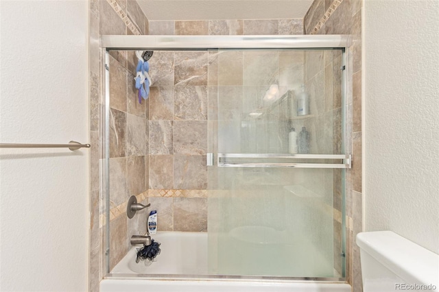 bathroom with shower / bath combination with glass door and toilet