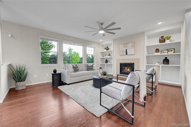 20145 E Fair Ln, Centennial, CO 80016 - living area with ceiling fan, wood finished floors, a tiled fireplace, built in shelves, and recessed lighting