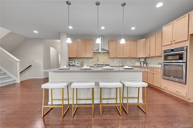 20145 E Fair Ln, Centennial, CO 80016 - kitchen with light brown cabinets, stainless steel double oven, wall chimney exhaust hood, backsplash, and a breakfast bar