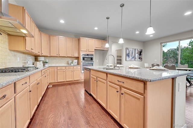 20145 E Fair Ln, Centennial, CO 80016 - kitchen with wall chimney range hood, light brown cabinetry, stainless steel appliances, wood finished floors, and light stone countertops