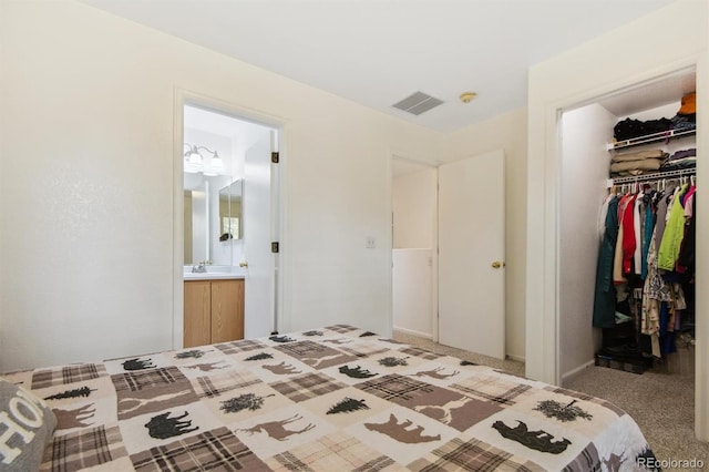 carpeted bedroom featuring ensuite bath and a closet