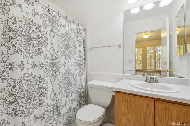 bathroom featuring toilet and vanity