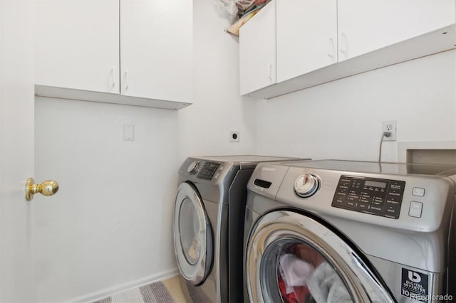 washroom with cabinets and washer and clothes dryer