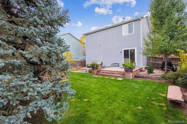 back of house featuring a lawn and a patio