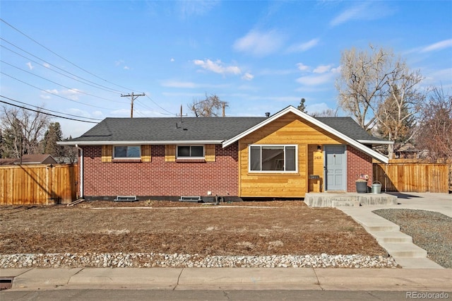 single story home featuring brick siding, a shingled roof, and fence