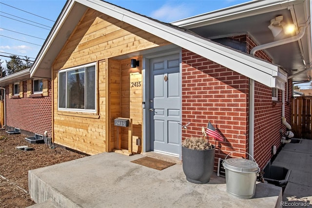 view of exterior entry featuring brick siding