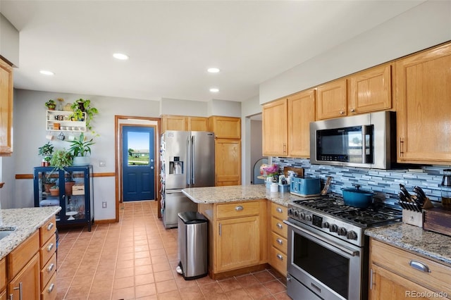 kitchen with appliances with stainless steel finishes, light tile patterned floors, light stone counters, and backsplash